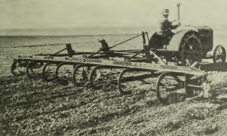 Archival 1935 photograph showing a rod weeder, a specialized farm implement designed to remove weeds with minimal soil disturbance, being pulled across a prairie field.