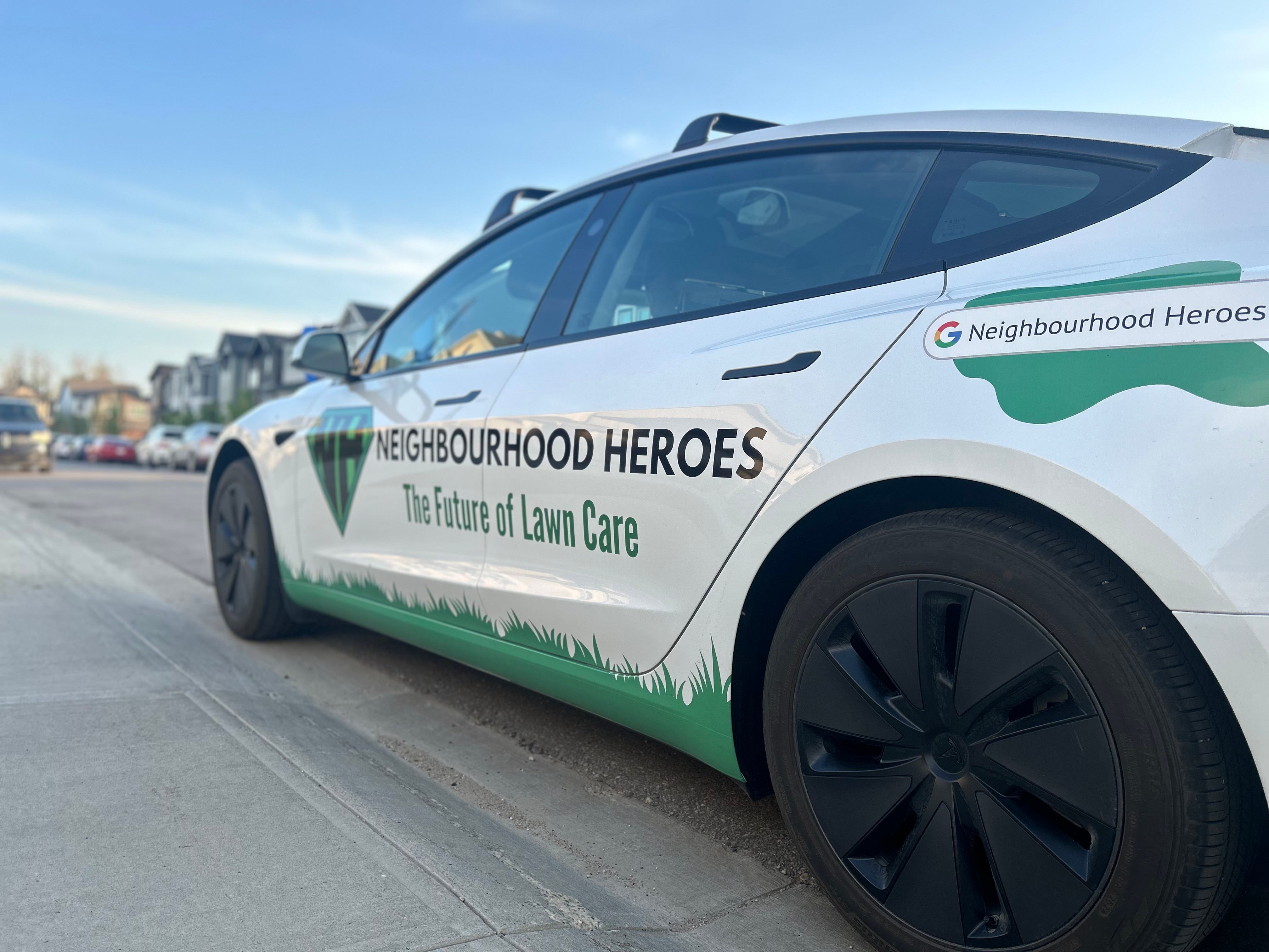 Close up image of a Neighbourhood Heroes lawn care Tesla in Edmonton
