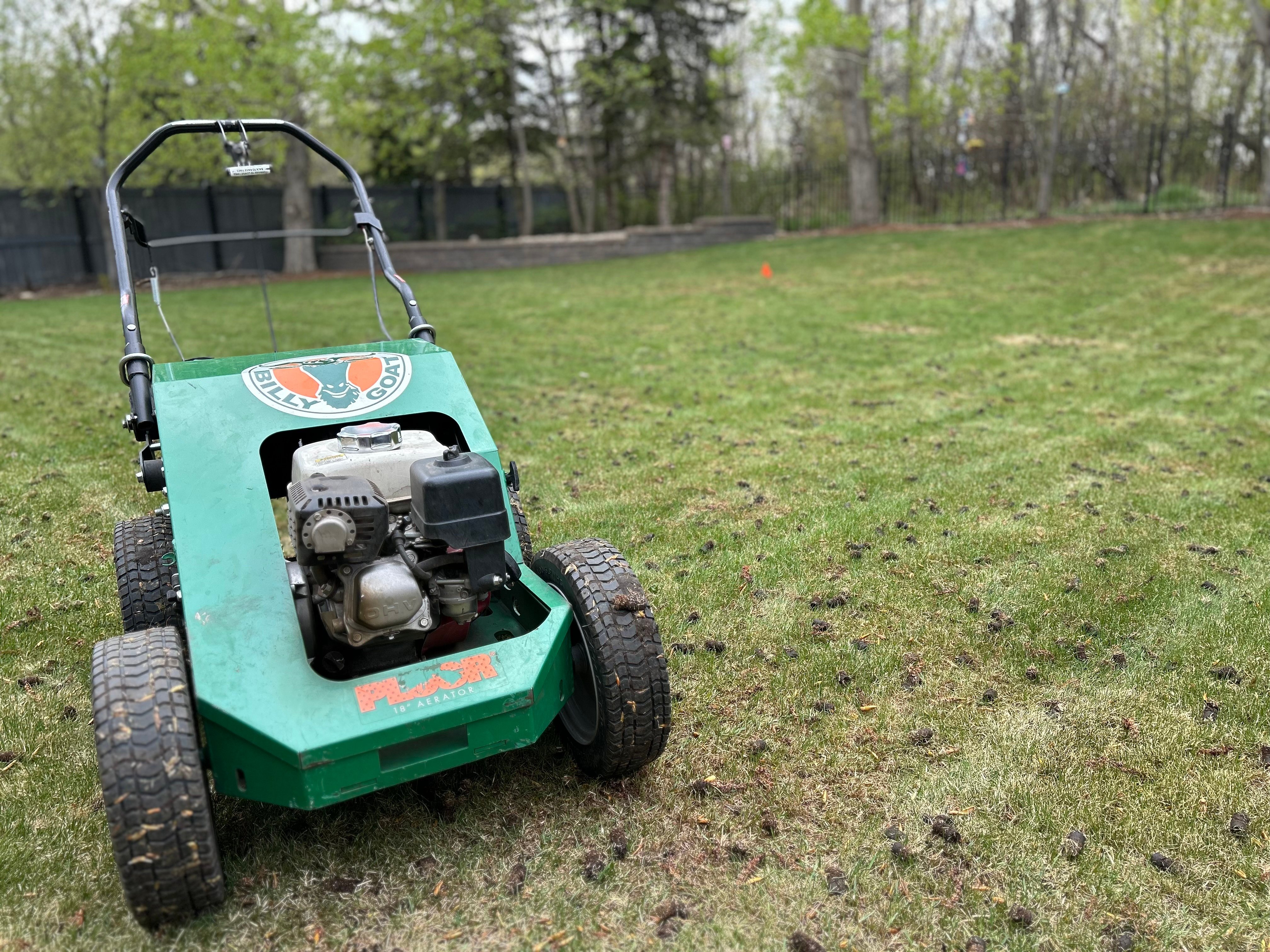 A mechanical aerator in front of an Edmonton lawn in the fall