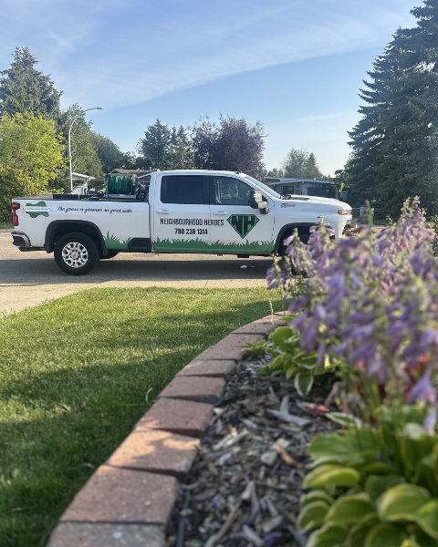 Neighbourhood Heroes Spray Truck parked by an Edmonton lawn
