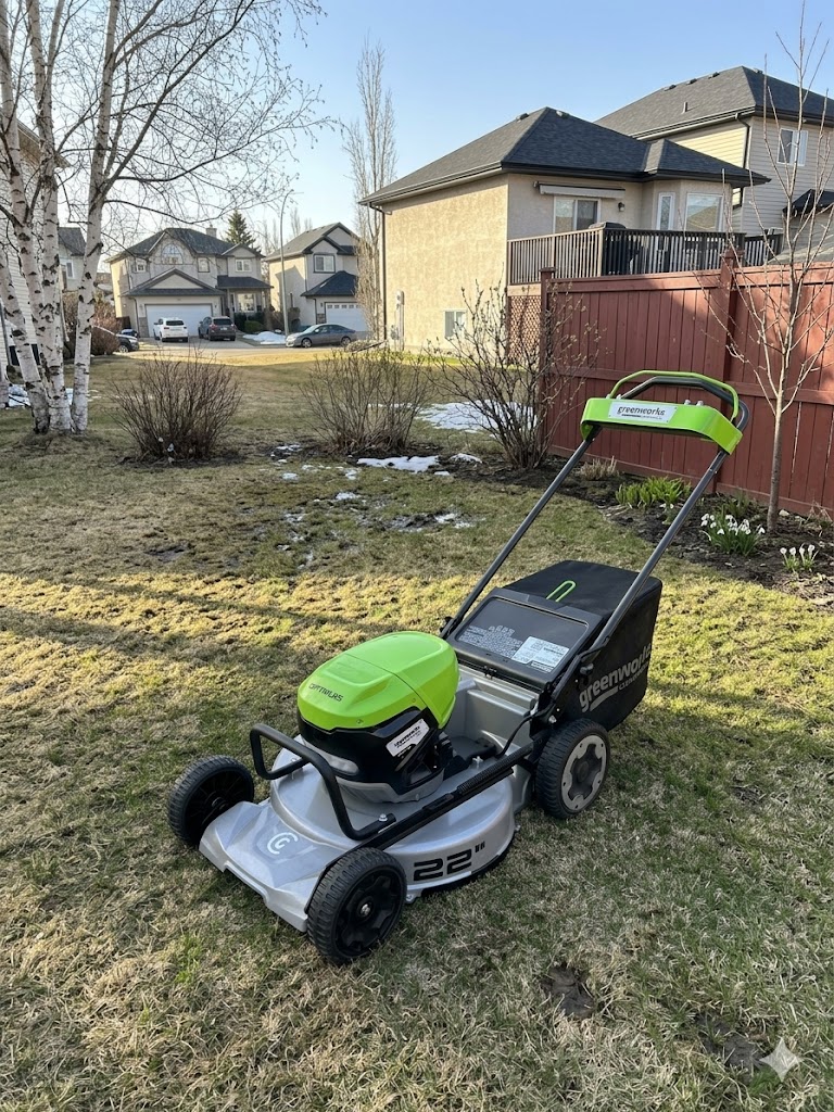 Battery-powered electric lawn mower on an Edmonton lawn in the spring. 